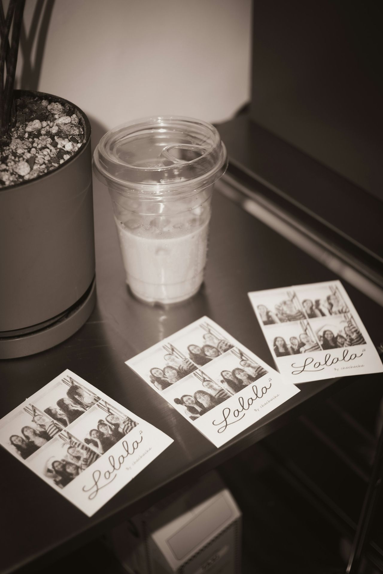 Tirages photobooth en noir et blanc posés sur une table après une soirée